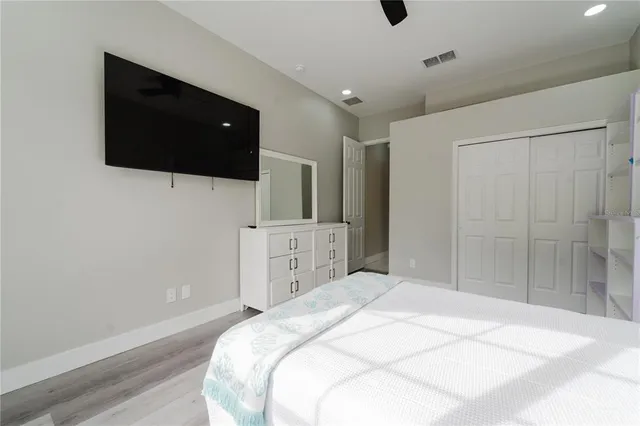 a spacious bedroom with a bed and a flat screen tv