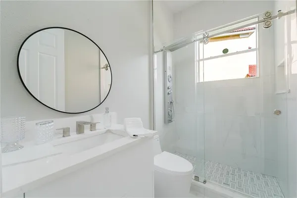 a bathroom with a sink mirror toilet and shower