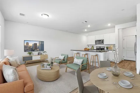 a living room with furniture and kitchen view