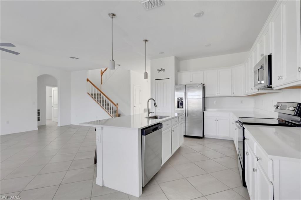 2553 Kona Way Naples, FL 34120 - Photo 5 of 27 a kitchen with stainless steel appliances granite countertop a sink a stove and a refrigerator