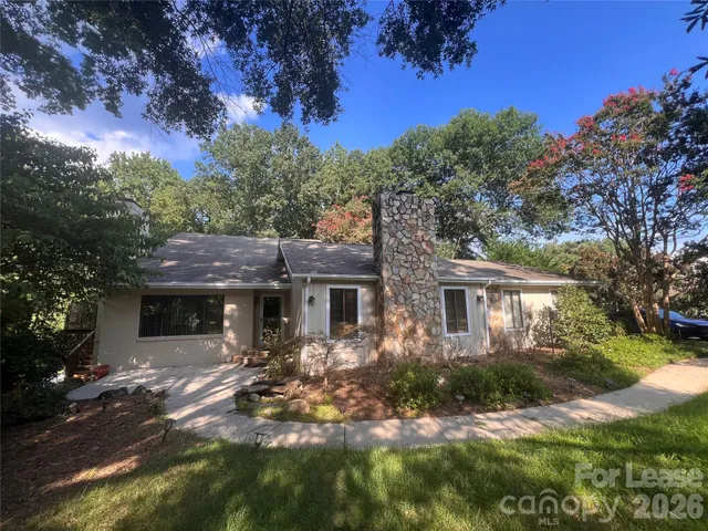 a front view of a house with a yard and green space