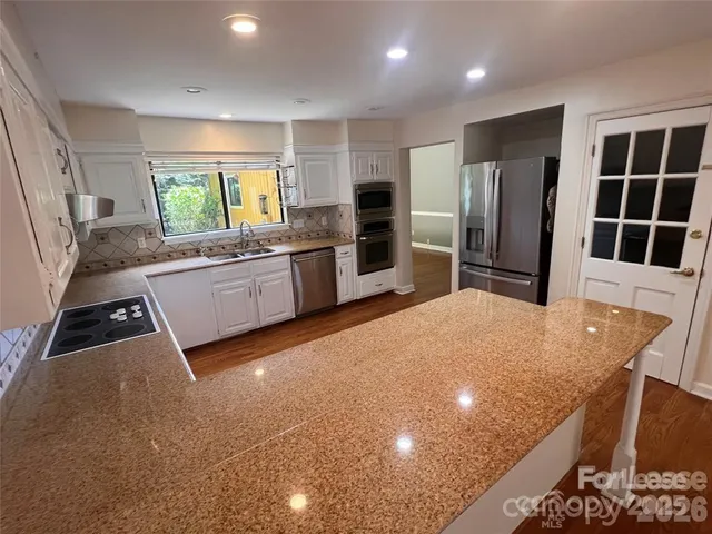 a kitchen with stainless steel appliances a refrigerator sink and stove