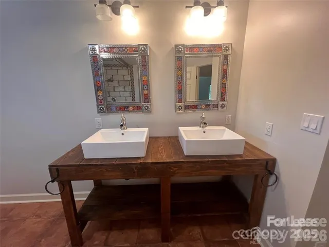 a bathroom with double sink and a mirror