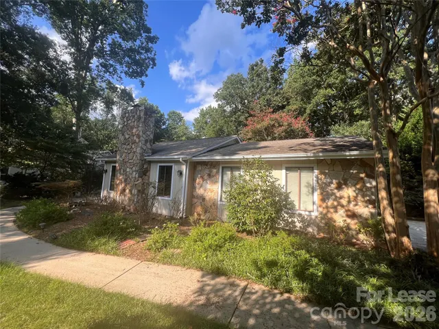 a view of backyard of house with green space