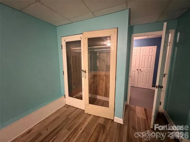 an empty room with wooden floor and entrance