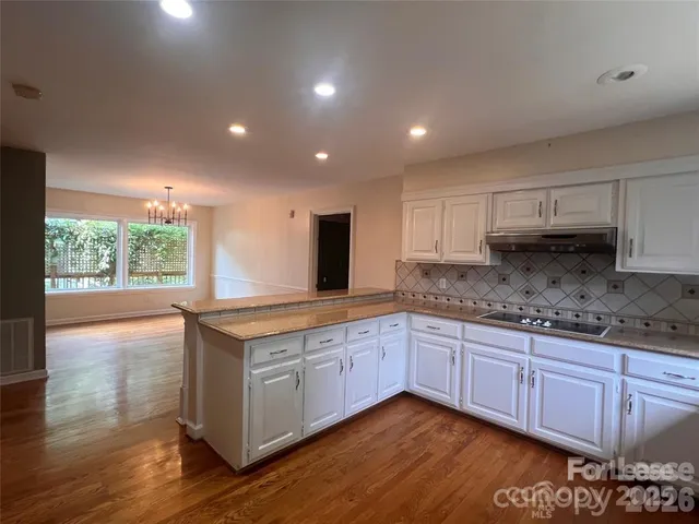 a kitchen with granite countertop a stove and a sink