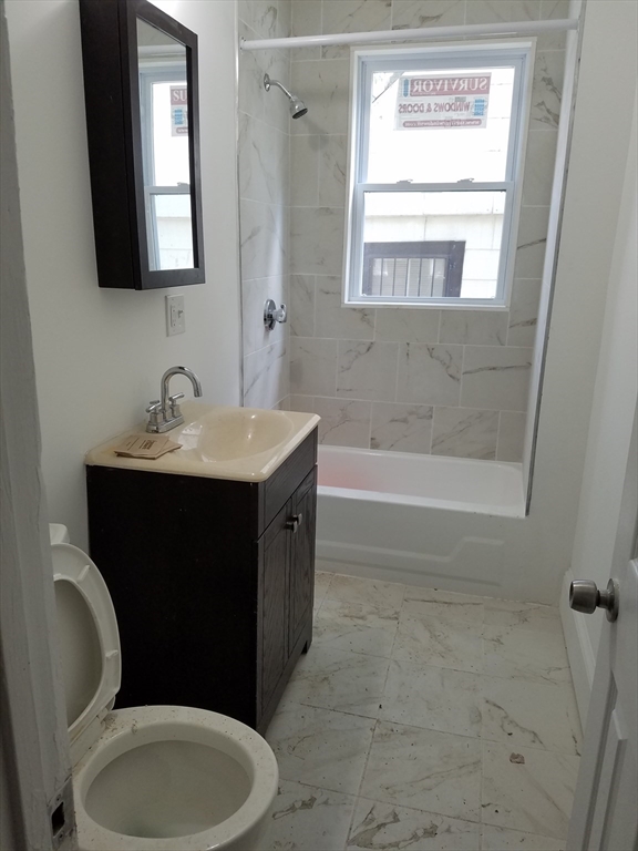 98 Topliff Street, Unit 2 Boston, MA 02122 - Photo 3 of 11 a bathroom with a sink vanity mirror bathtub and toilet