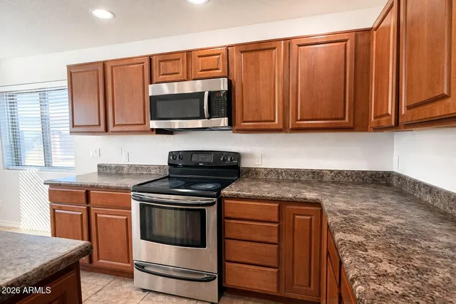 a kitchen with wooden cabinets and a stove top oven