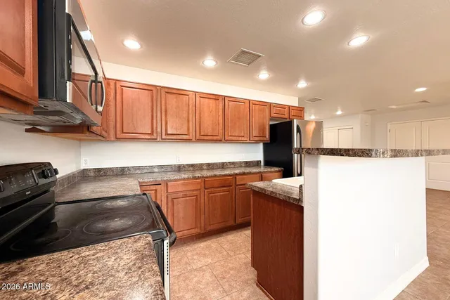 a kitchen with stainless steel appliances granite countertop a stove a sink and a refrigerator