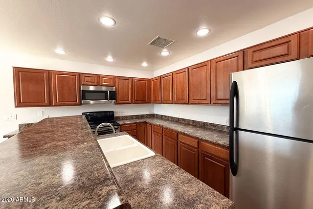 a kitchen with stainless steel appliances granite countertop a refrigerator sink and microwave