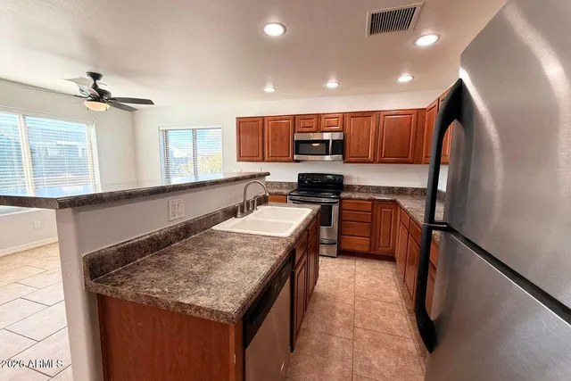 a kitchen with stainless steel appliances granite countertop sink stove top oven and cabinets