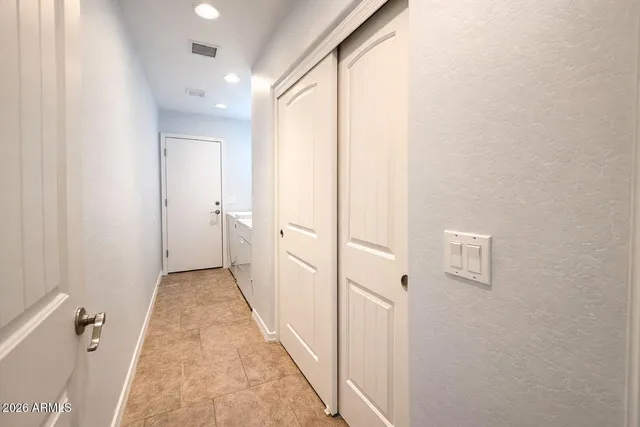 an empty room with windows and ceiling fan