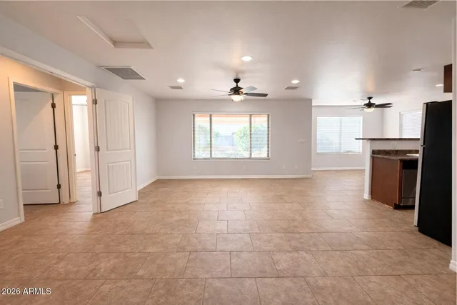 an empty room with windows and a fireplace