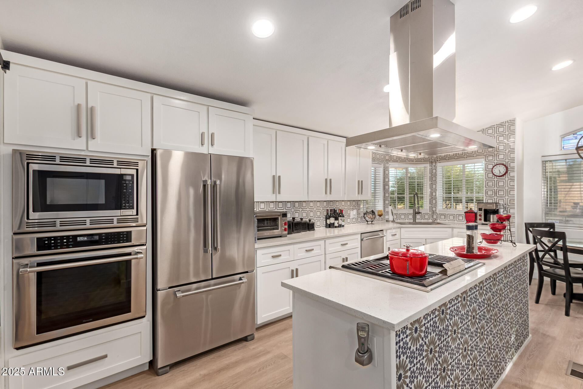 39234 West Buckeye Road Tonopah, AZ 85354 - Photo 10 of 40 a kitchen with a refrigerator a stove a sink dishwasher and white cabinets with wooden floor