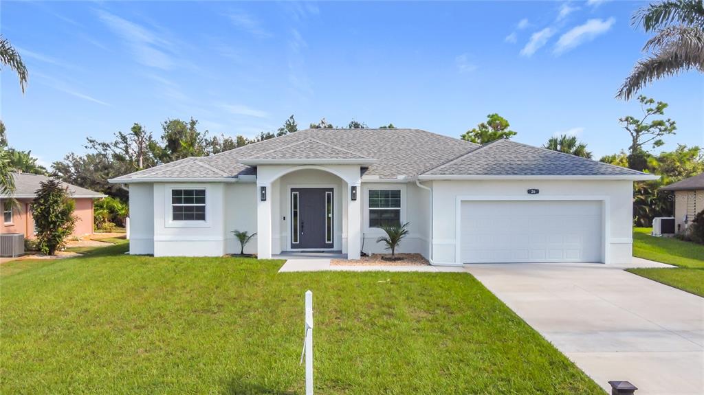 26 Medalist Way Rotonda West, FL 33947 - Photo 19 of 63 a front view of a house with a yard and garage