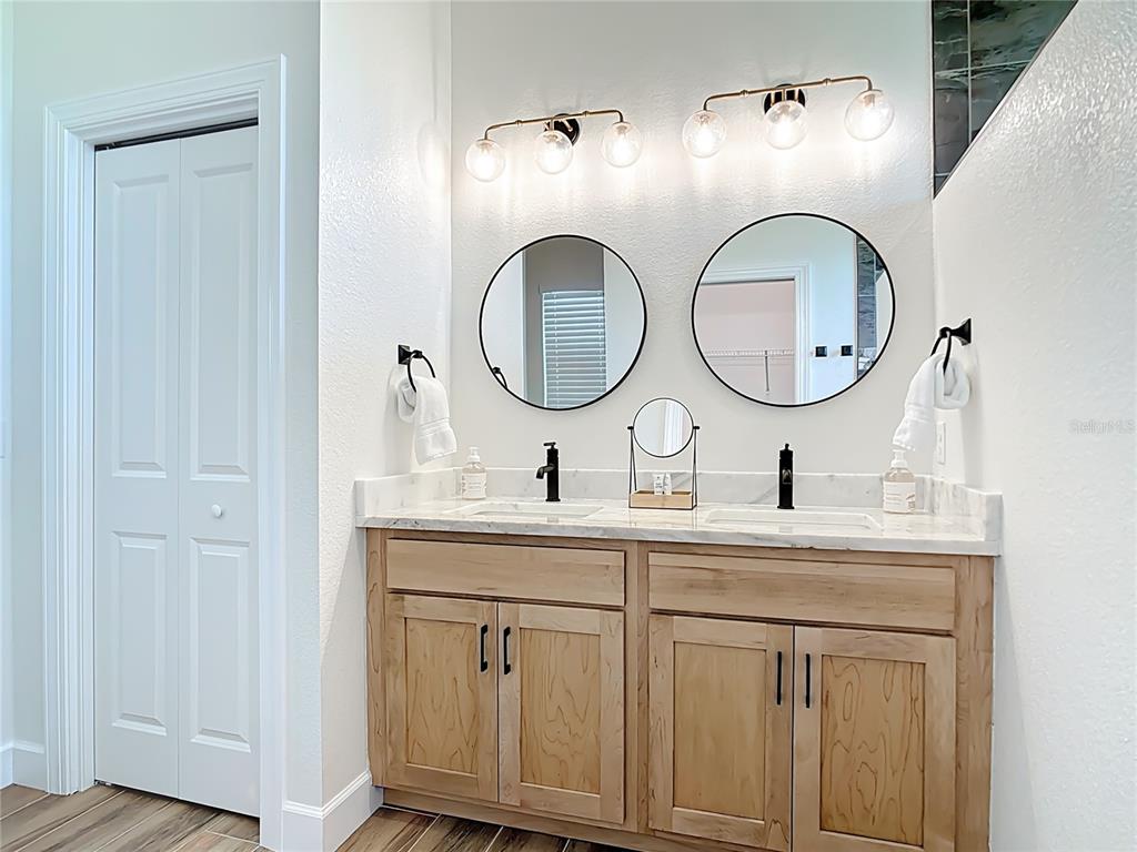 26 Medalist Way Rotonda West, FL 33947 - Photo 45 of 63 a bathroom with a granite countertop double vanity sink and a mirror