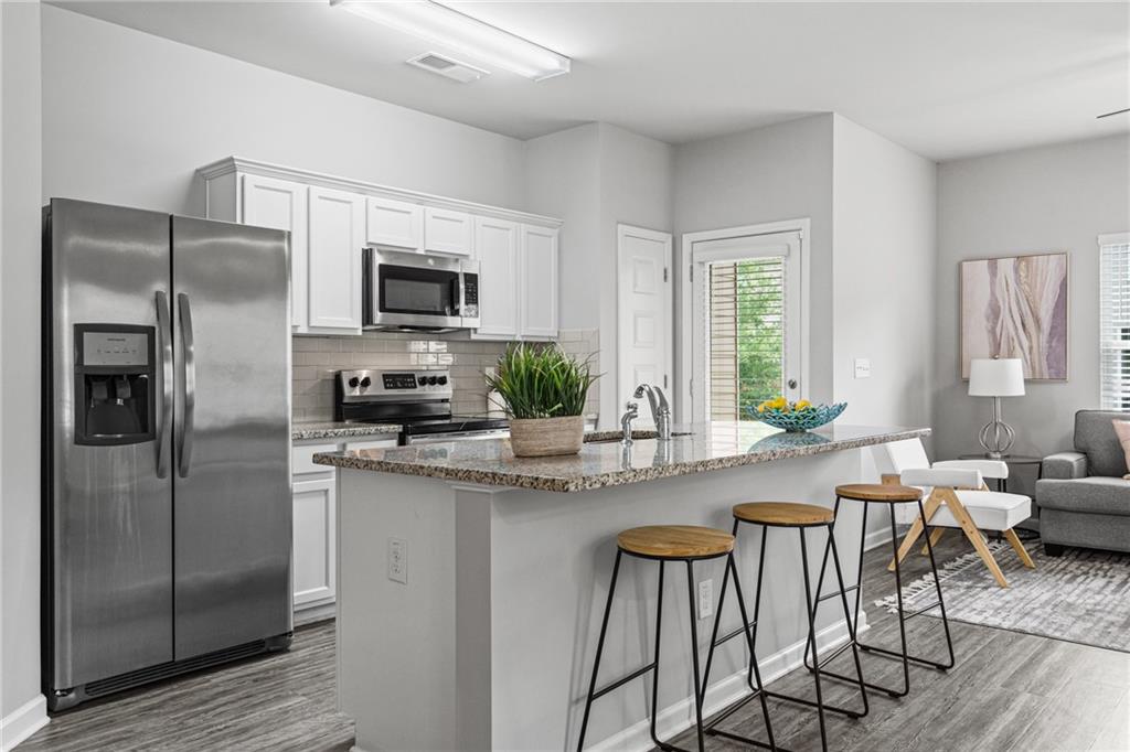 a kitchen with a refrigerator and a stove top oven