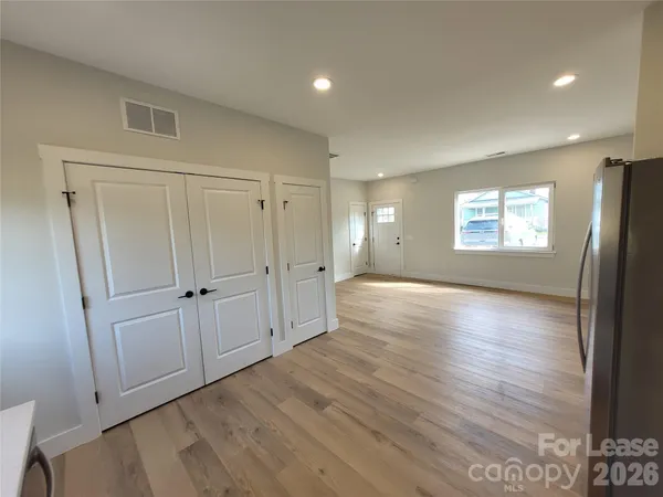 a view of empty room with window and wooden floor