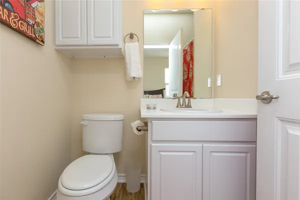 a bathroom with a sink vanity mirror and toilet