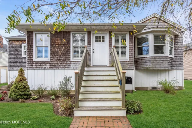 a front view of a house with a garden and plants