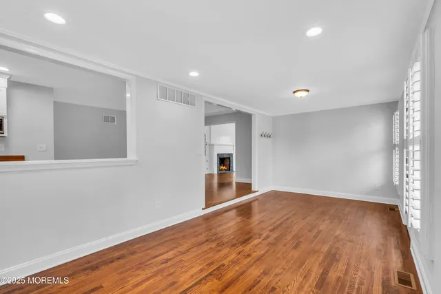a kitchen with stainless steel appliances a sink and wooden floor