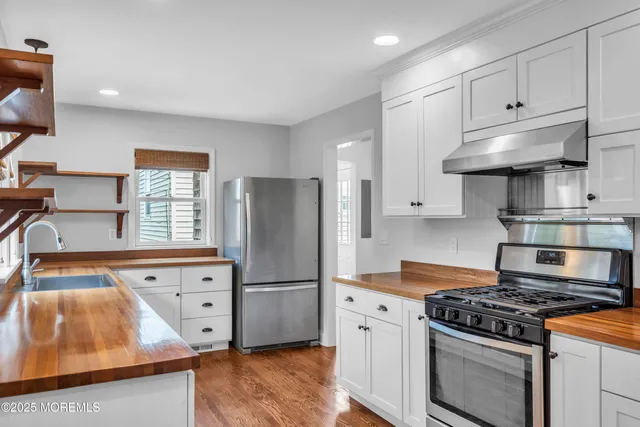 a view of empty room with wooden floor and fireplace