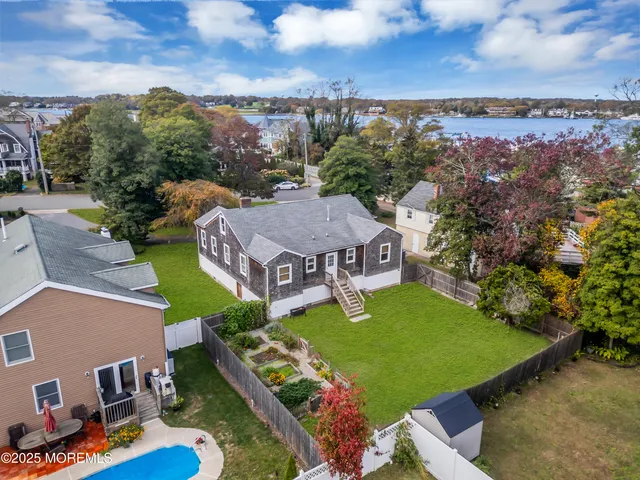 an aerial view of a house with garden space and ocean view
