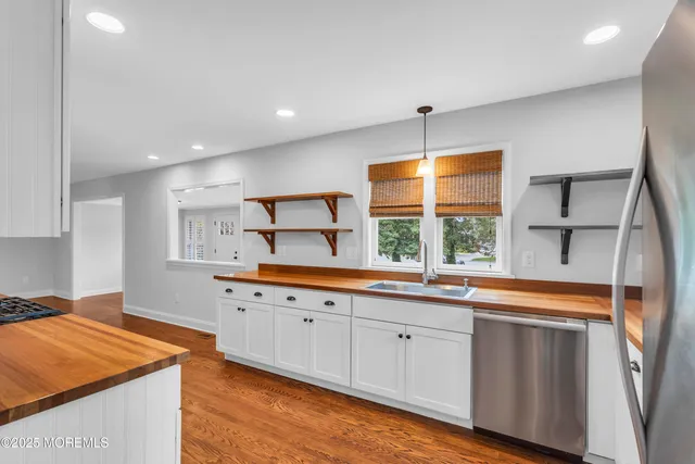 a view of a hallway with wooden floor and closet