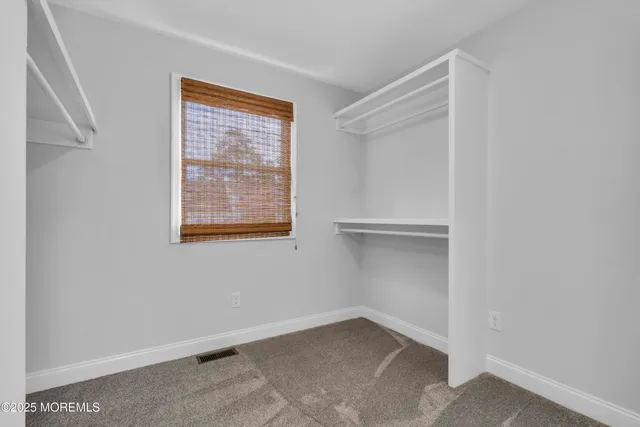 a front view of a house with a yard and a large tree