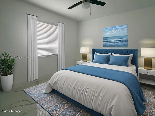 a bedroom with a large bed and a potted plant
