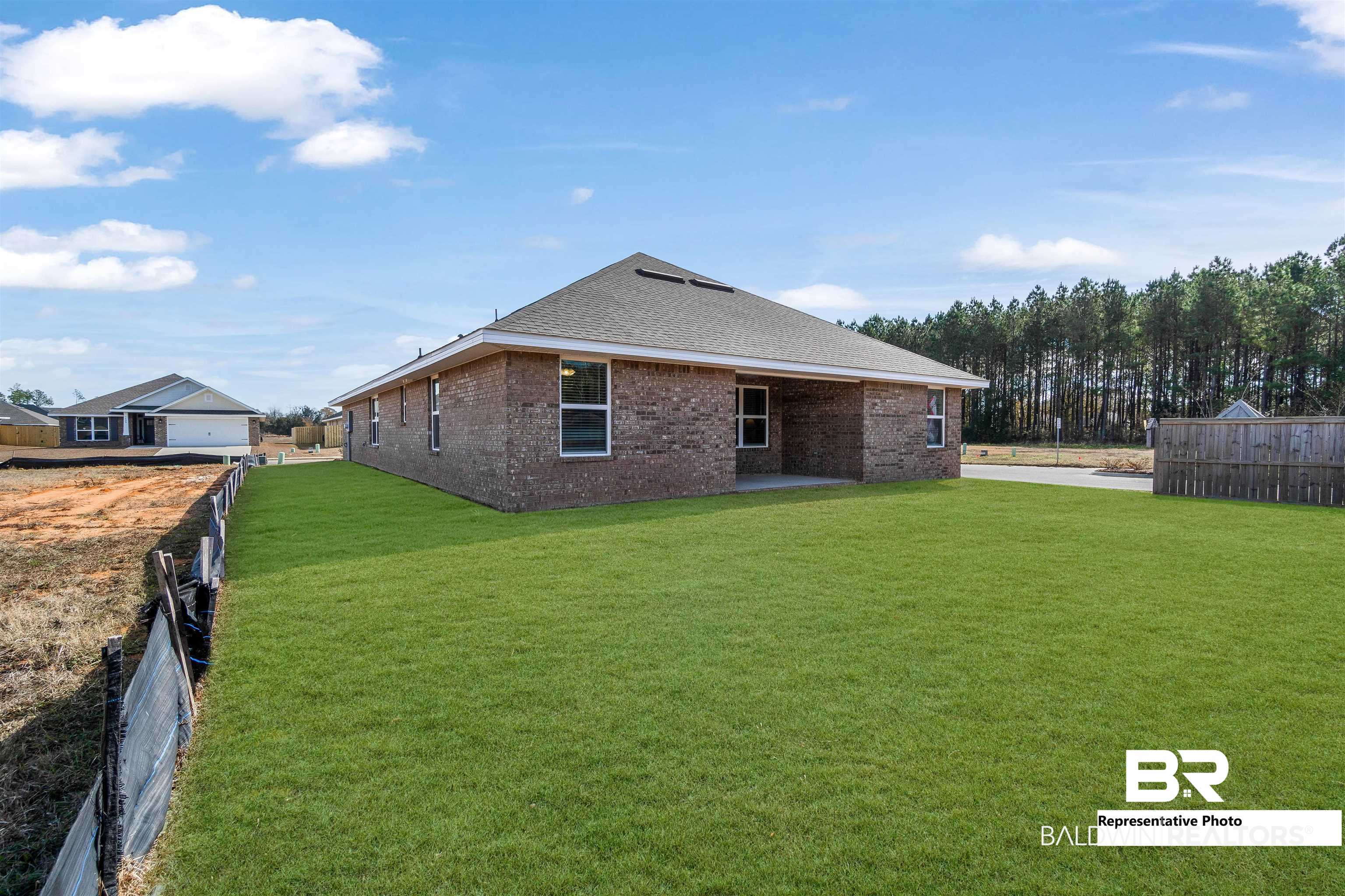 643 Mayflower Drive Foley, AL 36535 - Photo 33 of 34 Back of property with a shingled roof, fence, a lawn, and brick siding