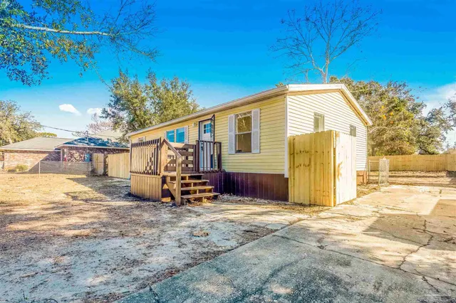a view of a house with backyard and a tree
