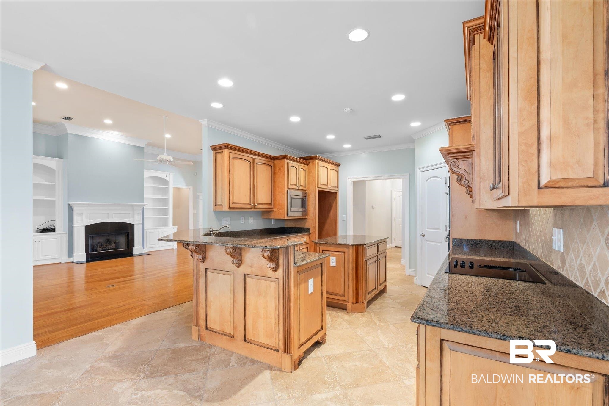 10730 Flagstone Drive Mobile, AL 36608 - Photo 8 of 20 Kitchen featuring stainless steel microwave, built in features, a center island, dark stone countertops, and ornamental molding