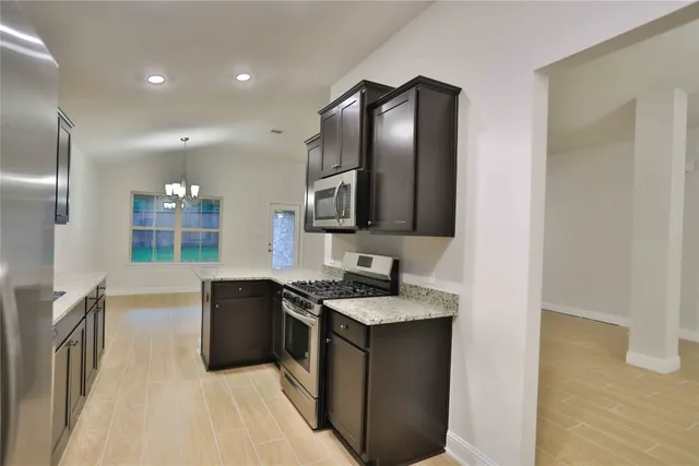 a kitchen with stainless steel appliances granite countertop a sink and a stove