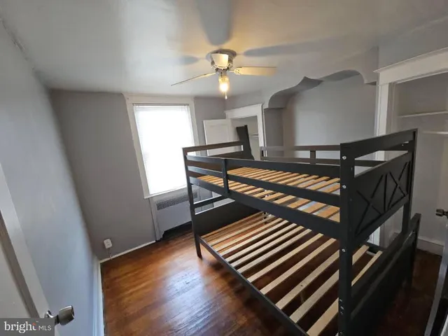 an empty room with a hardwood and ceiling fan