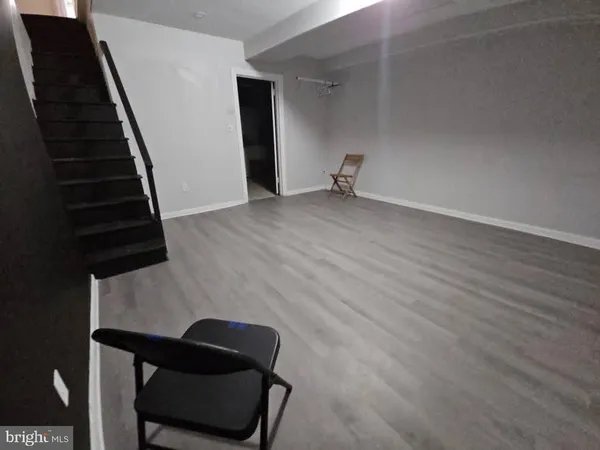 a view of an empty room with stairs and a window