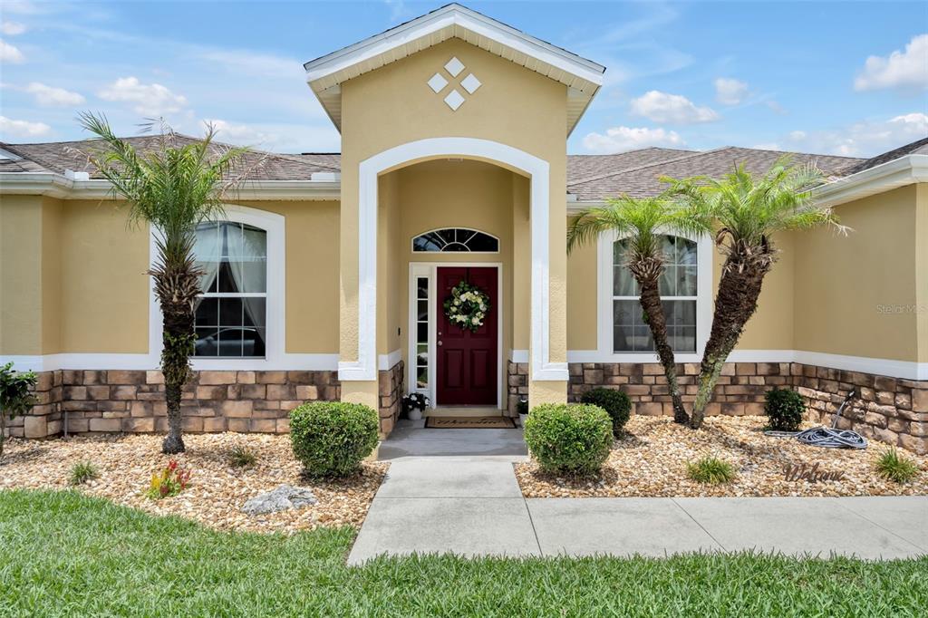 4946 Northeast 124th Road Oxford, FL 34484 - Photo 3 of 69 a front view of a house with garden