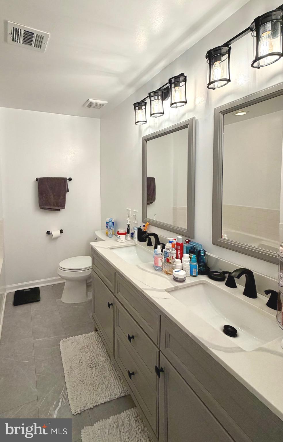 7108 Wheeling Way Gainesville, VA 20155 - Photo 24 of 45 a bathroom with a double vanity sink mirror and toilet