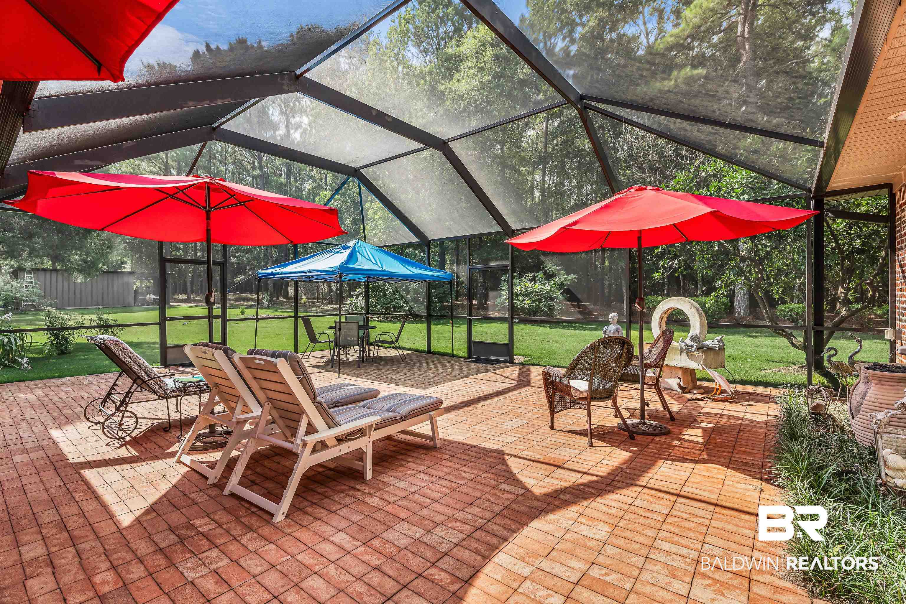 7014 Blakeley Road Daphne, AL 36527 - Photo 16 of 45 Expansive screened patio featuring a red brick-paver surface, a high-pitched screened enclosure, and direct access to a manicured lawn area