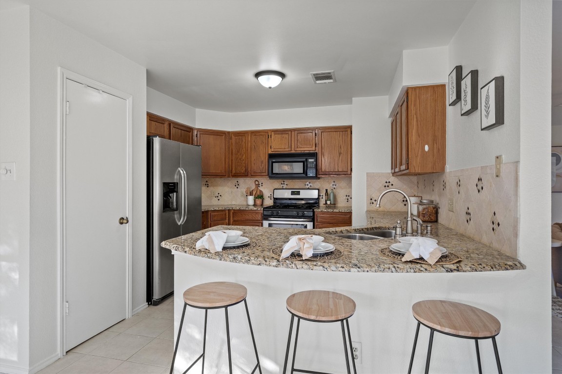 2602 Rainfall Trail Cedar Park, TX 78613 - Photo 11 of 36 a kitchen with stainless steel appliances granite countertop a refrigerator and a stove top oven
