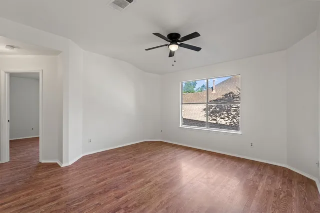 a view of a big room with wooden floor closet and windows