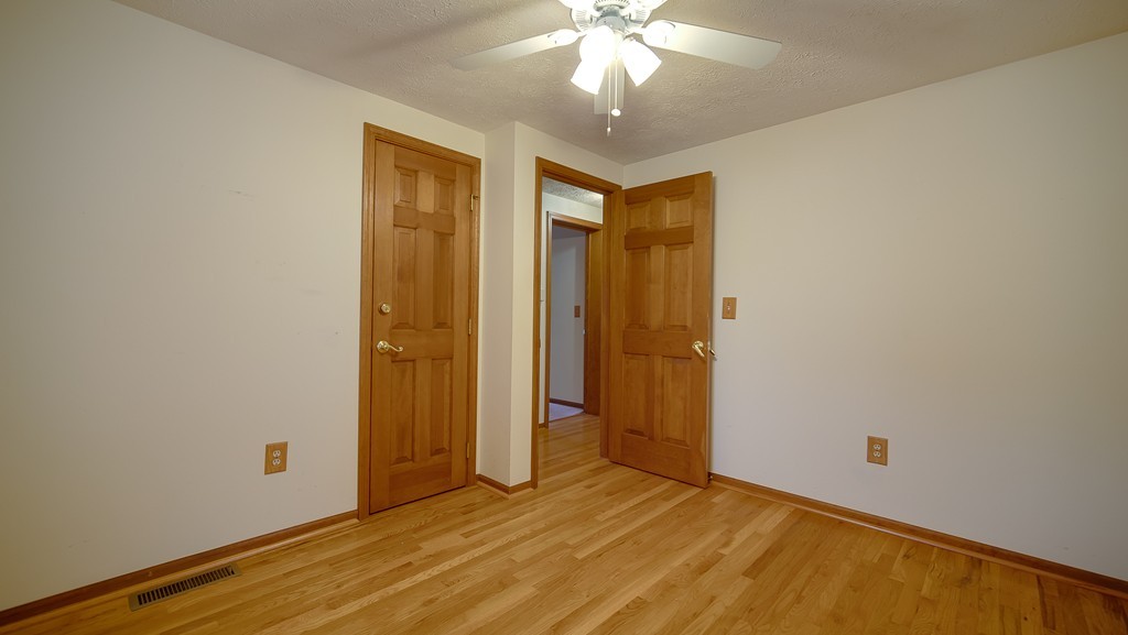 986 Allen Street Springfield, MA 01118 - Photo 19 of 30 an empty room with wooden floor and a ceiling fan