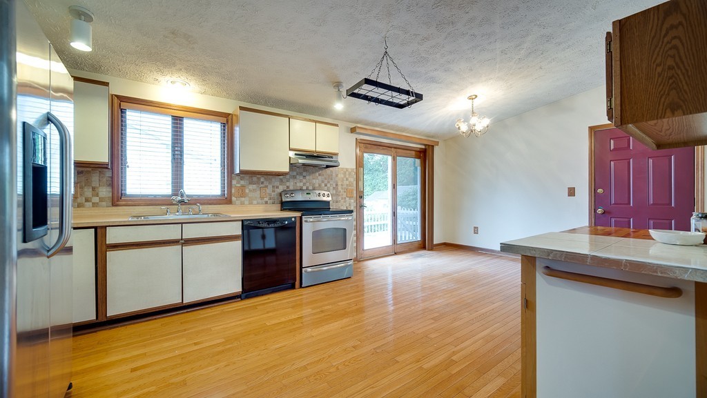 986 Allen Street Springfield, MA 01118 - Photo 4 of 30 a kitchen with stainless steel appliances granite countertop a sink stove and refrigerator