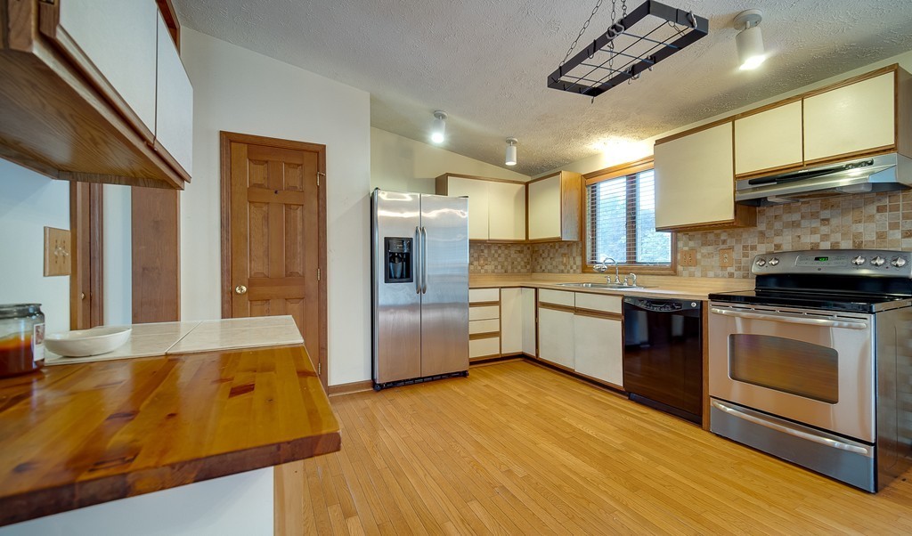 986 Allen Street Springfield, MA 01118 - Photo 5 of 30 a kitchen with stainless steel appliances granite countertop a sink a stove top oven a chimney and a center island
