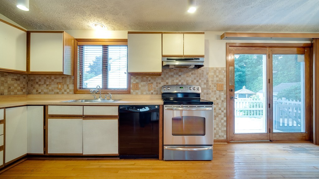986 Allen Street Springfield, MA 01118 - Photo 6 of 30 a kitchen with a sink a stove cabinets and wooden floor