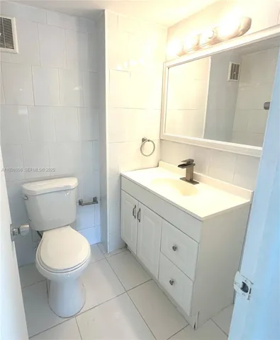 a bathroom with a double vanity sink toilet and mirror