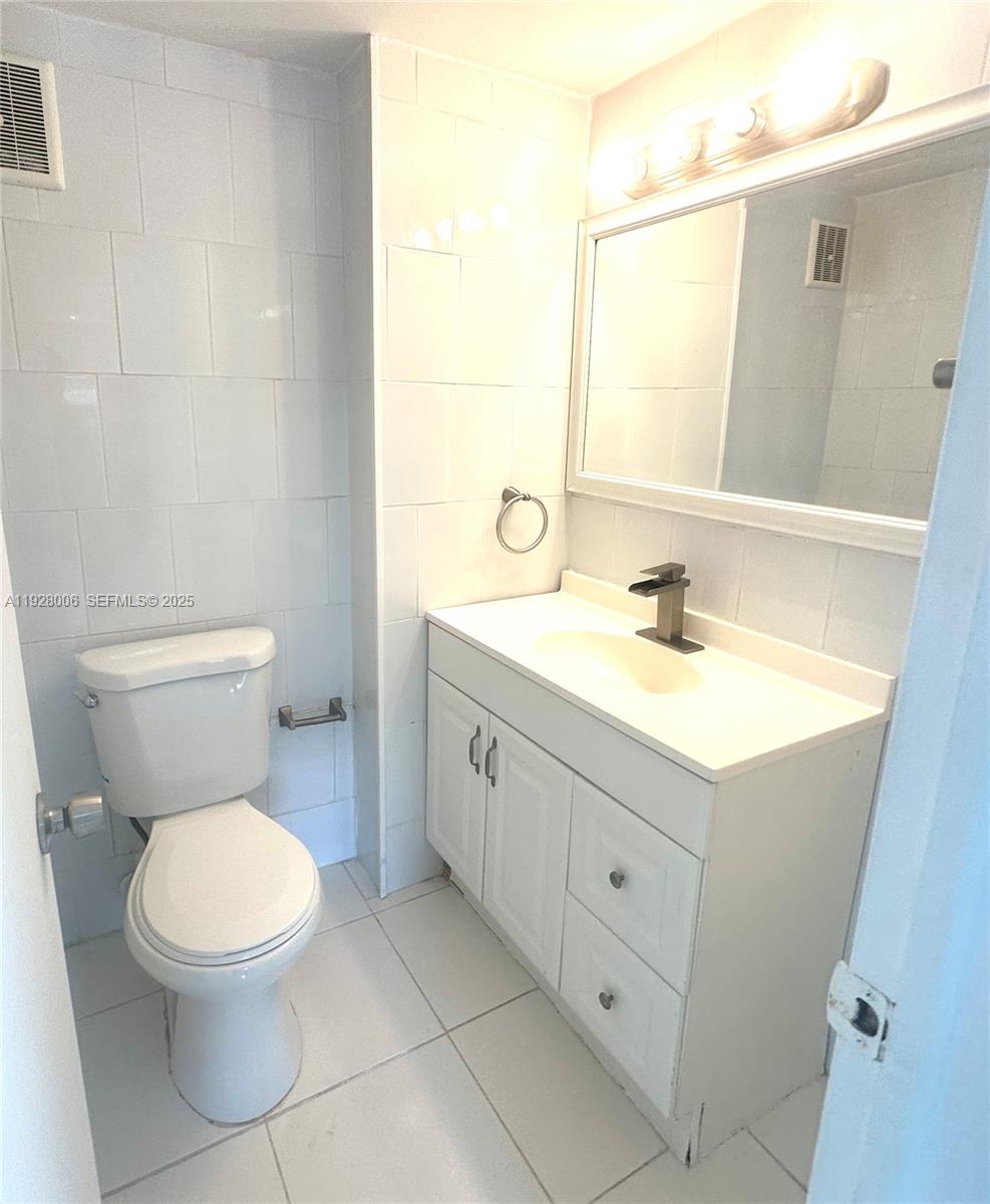 250 180th Drive, Unit 254 Sunny Isles Beach, FL 33160 - Photo 15 of 36 a bathroom with a toilet a sink a mirror and a shower
