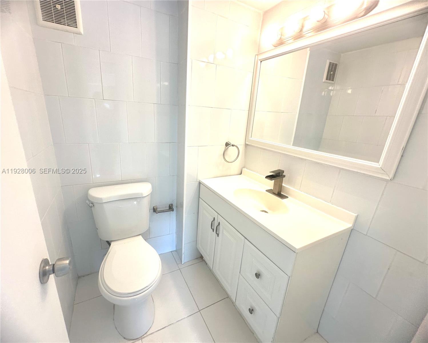 250 180th Drive, Unit 254 Sunny Isles Beach, FL 33160 - Photo 16 of 36 a bathroom with a double vanity sink toilet and mirror