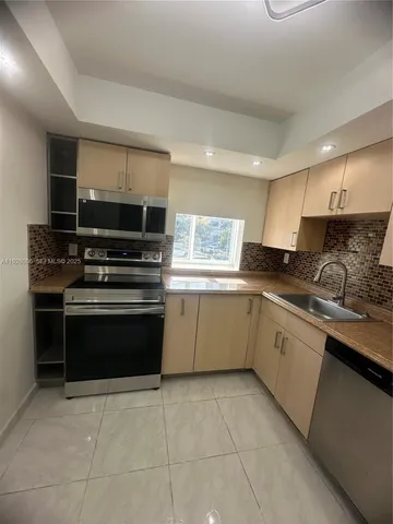 a kitchen with a sink stove and microwave