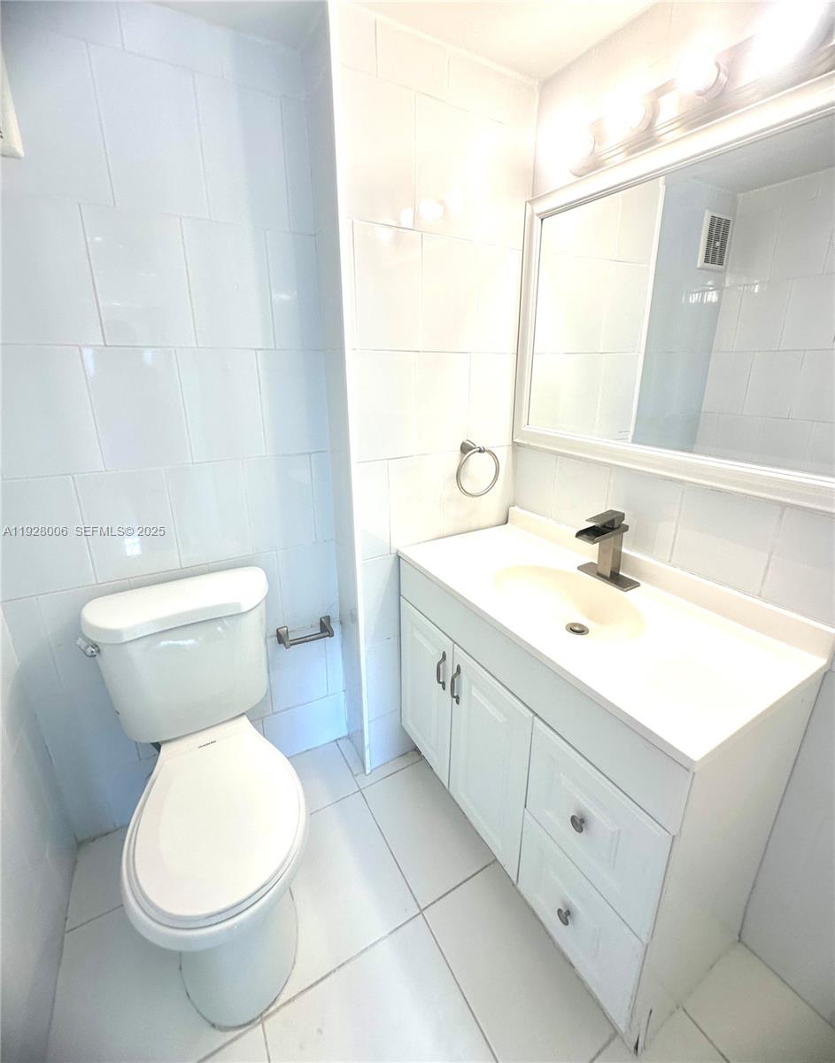 250 180th Drive, Unit 254 Sunny Isles Beach, FL 33160 - Photo 7 of 36 a bathroom with a toilet sink and mirror